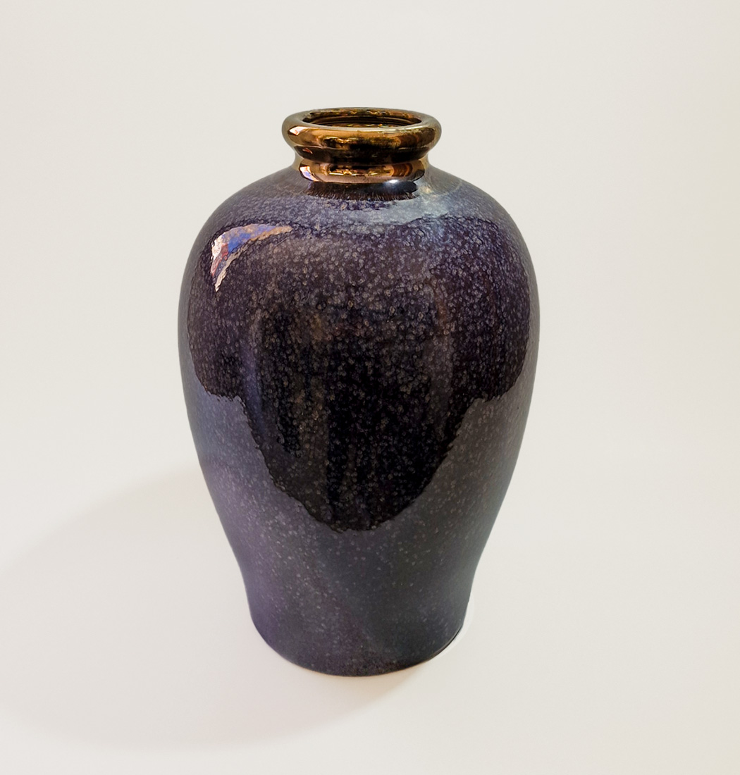 Blue ceramic vase with purple mixture and gold top
