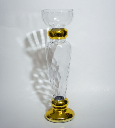Glass candlestick with metallic base in gold color
